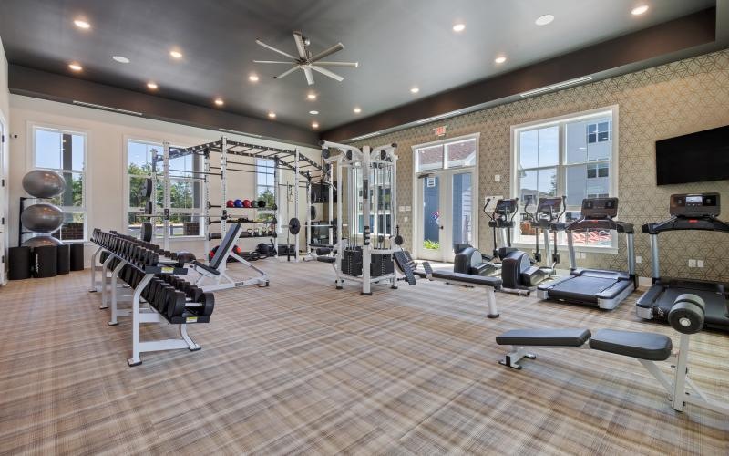 a room with exercise equipment and a wood floor